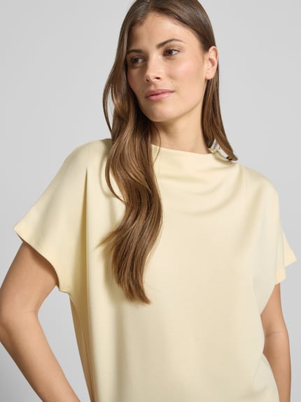 Vrouwenmodel draagt Regular Fit T-Shirt uit elastische viscose-mix, model 'Kiline' van Someday, lichte kleur, opstaande kraag, close-up bovenlichaam.