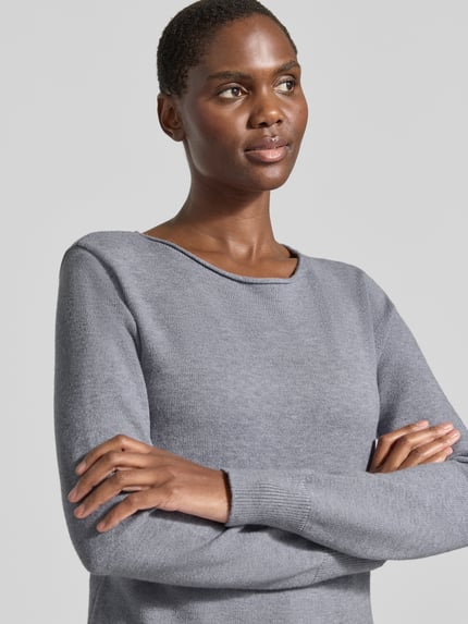 Frauenmodel trägt Regular Fit Strickpullover aus Viskose-Mix mit U-Boot-Ausschnitt von Christian Berg Woman, grauer Farbton, gerippte Abschlüsse, langärmeliges Design mit überschnittenen Schultern, Nahaufnahme Oberkörper.