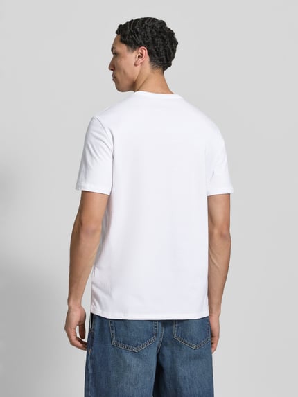 Männermodel trägt T-Shirt mit Rundhalsausschnitt und Logo von Calvin Klein Jeans in Weiß, reine Baumwolle, Regular Fit, Ganzkörperansicht Rückansicht.