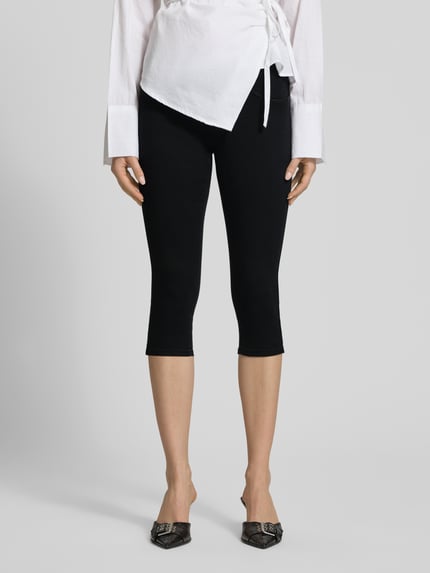 Frauenmodel trägt Regular Fit Caprijeans aus Viskose-Mix Modell 'RAIN' von Only, 3/4-Länge, schwarze Denimoptik, Nahaufnahme Unterkörper.