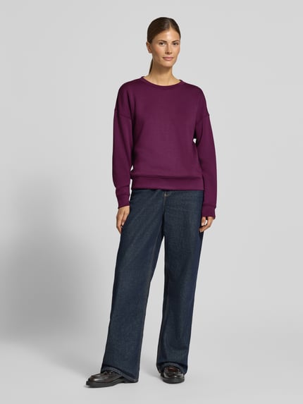 Vrouwenmodel draagt Relaxed Fit Sweatshirt uit elastische viscose-mix model 'Ima' van MSCH Copenhagen, paars, donkere jeans, casual, volledige vooraanzicht.