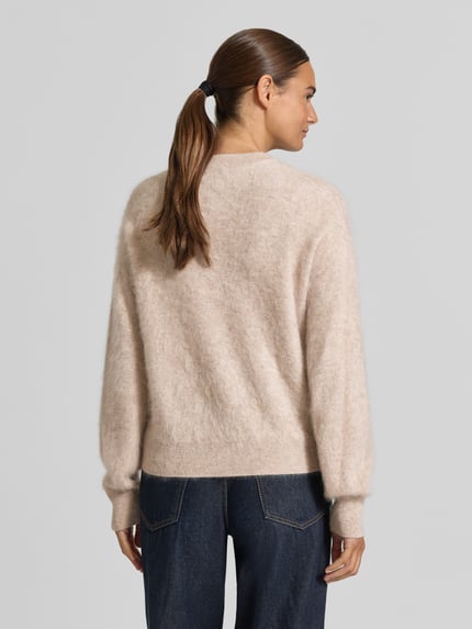 Frauenmodel trägt Regular Fit Pullover aus reinem Kaschmir von Jake*s Casual in Beige mit weicher Textur, Ganzkörperansicht Rückansicht.