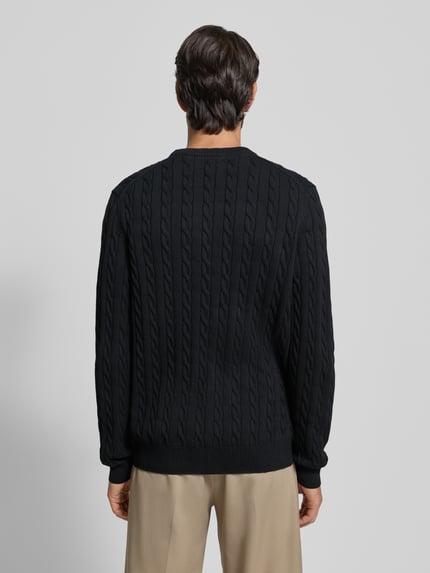 Mannenmodel draagt Gebreide pullover met ribboorden van Christian Berg Men, puur katoen, regular fit, zwarte kleur, ruglengte maat M 70 cm, mouwlengte maat M 70 cm, ronde hals, structuur met kabelpatroon, Ganzkörperansicht Rückansicht.