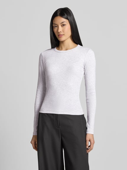 Frauenmodel trägt Slim Fit Langarmshirt aus Baumwoll-Mix Modell 'CHLOE' von VERO MODA in Hellgrau, schlichte Struktur, Ganzkörperansicht von vorne. Damen Langarmshirt von VERO MODA.