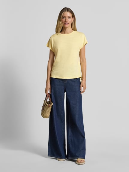 Frauenmodel trägt Regular Fit T-Shirt mit Viskose-Anteil von Apricot, Damen T-Shirt im Strukturmuster, Zierschleife, Elastischer-Material-Mix, Rückenlänge bei Größe S 59 cm, Ganzkörperansicht von vorne.