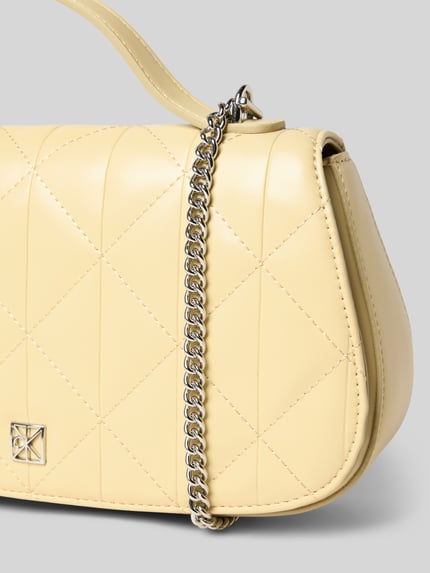 Produktfoto, Umhängetasche mit Logo-Applikation von CK Calvin Klein in cremefarbener Quilted-Optik, silberner Ketten-Optik, Hauptfach mit Überschlag, Maße 26x15x6 cm, Schulterriemen 112 cm.