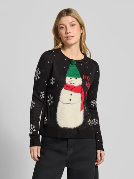 Frauenmodel trägt Pullover mit flauschigem Schneemann-Motiv von VERO MODA, mehrfarbig, Strickoptik, Motiv-Print, Rundhals, Ganzkörperansicht von vorne.