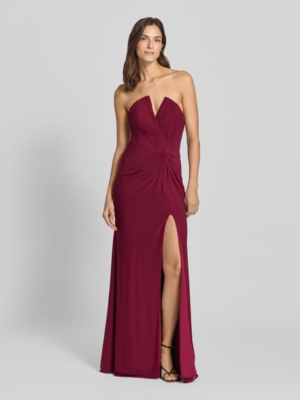 Frauenmodel trägt Off-Shoulder-Kleid mit Knotendetail von Mascara, figurnaher Schnitt, V-Ausschnitt, Maxikleid, Chiffon, Ganzkörperansicht von vorne.