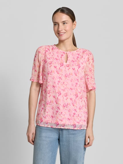 Modelka nosi Blusenshirt mit Schlüsselloch-Ausschnitt Modell 'EMMA' von Vila w różowy, wzór allover, krój regular fit, długość tyłu 60 cm, długość rękawa 29 cm, widok całej sylwetki z przodu.