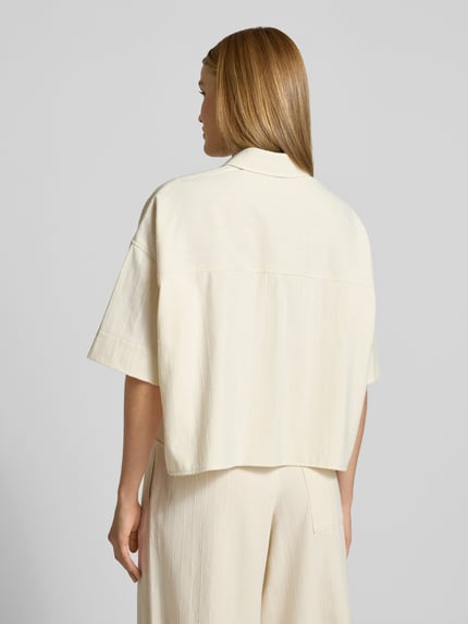 Vrouwenmodel draagt Boxy Fit Bluse mit 1/2-Arm Modell 'YARIKA' van Drykorn, katoenmix met kasjmier, overhemdkraag, ruglengte 54 cm, lichte kleur, gestructureerde stof, Ganzkörperansicht Rückansicht.
