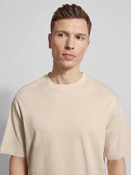 Männermodel trägt Relaxed Fit T-Shirt aus reiner Baumwolle Modell 'RELEXASPEN' von SELECTED HOMME, unifarben, fijnrib, ronde hals, korte mouw, Nahaufnahme Oberkörper