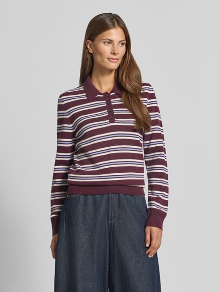 Frauenmodel trägt Regular Fit Pullover aus reiner Wolle von GANT in Bordeaux mit weißen und lila Streifen, Ganzkörperansicht von vorne. Damen Pullover von GANT.