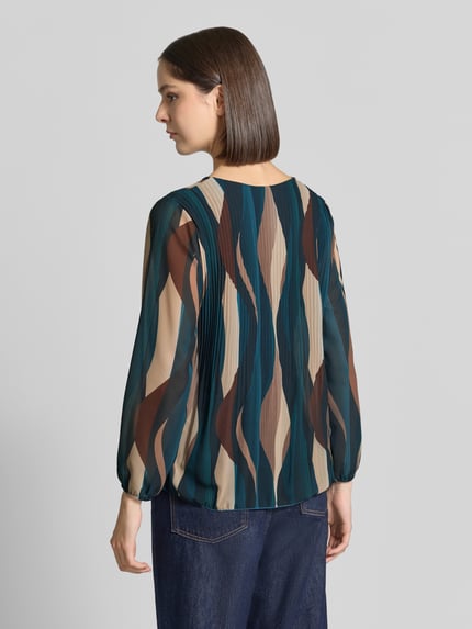 Frauenmodel trägt Bluse mit Plisseefalten Modell 'Re44ynaa' von ZABAIONE, bunte Streifenoptik, Chiffon, Ganzkörperansicht Rückansicht.
