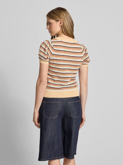 Frauenmodel trägt Regular Fit Strickshirt mit kurzem Arm Modell 'KAMIA LUREX' von Pepe Jeans, Optik:Allover-Muster, gestreift, Struktur, Effektgarn, Kurzarm, Crew Neck, Rumpfabschluss: Gerippt, Materialverarbeitung: Strick, Baumwoll-Mix, Farben in Beige, Orange und Blau, Ganzkörperansicht Rückansicht.