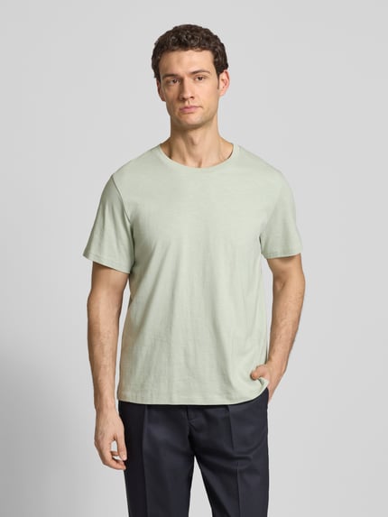 Männermodel trägt Regular Fit T-Shirt aus reiner Baumwolle Modell 'HASPEN' von Selected Homme in Melange-Optik, Rundhals, Kurzarm, Ganzkörperansicht von vorne.