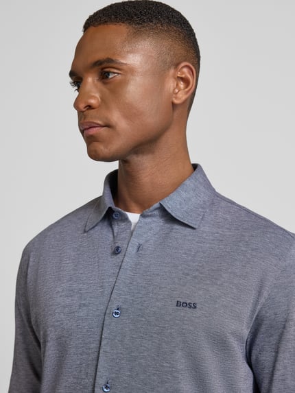 Mannelijk model draagt Slim Fit Freizeithemd uit pure katoen model 'MYSOFT_2' van BOSS Orange, effen melange, close-up bovenlichaam.