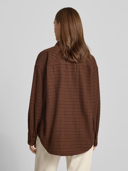 Vrouwenmodel draagt Oversized Fit Hemdbluse aus reiner Baumwolle mit borstzak van REVIEW in bruin geruit patroon, rugaanzicht, Puur katoen, oversized fit, borstzak, doorlopende knoopsluiting, lange mouw, overhemdkraag, verlaagde schouders, ruglengte maat S 74 cm, mouwlengte maat S 53 cm.