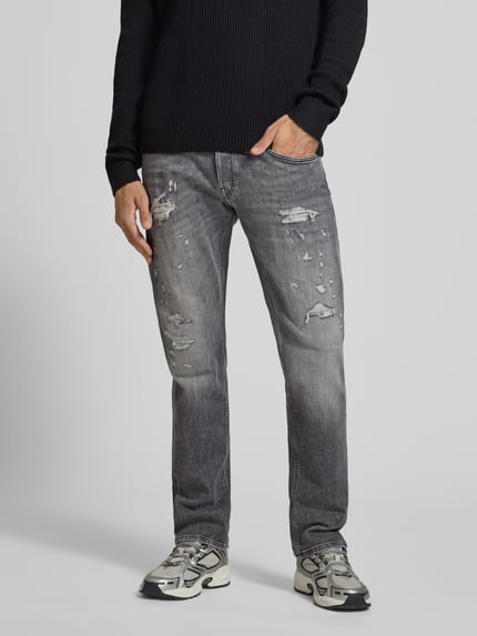 Männermodel trägt Straight Fit Jeans im Used-Look Modell 'Grover' von Replay, 5-Pocket-Design, graue Waschung, Ganzkörperansicht von vorne. Baumwoll-Mix mit Stretch-Anteil, Knopf- und Reißverschluss, Bundweite 46 cm, Innenbeinlänge 82 cm.
