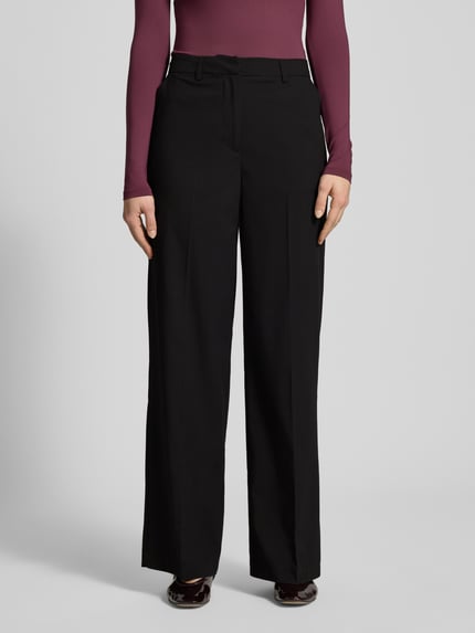 Frauenmodel trägt schwarze Bundfaltenhose mit Viskose-Anteil Modell 'ROSA' von Pieces, Wide Leg, High Waist, Nahaufnahme Oberkörper.