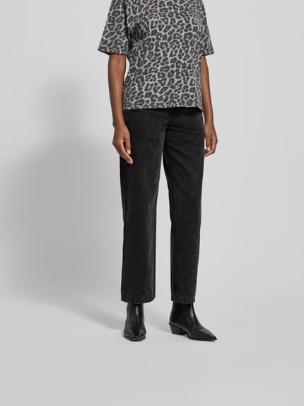 Frauenmodel trägt Jeans mit 5-Pocket-Design von black palms, schwarze reine Baumwolle, lockerer Schnitt, Nahaufnahme Unterkörper.