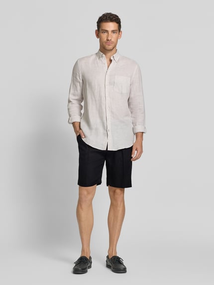 Männermodel trägt Shorts aus Leinen mit Eingrifftaschen von MARKUP, schwarze Farbe, Straight Fit, Ganzkörperansicht von vorne, Herren Shorts, reine Leinen, Knopf-Reißverschluss, französische Eingrifftaschen, Gesäßleistentaschen mit Knopfverschluss, Bundweite bei Größe 50: 22 cm, Innenbeinlänge bei Größe 50: 34 cm.