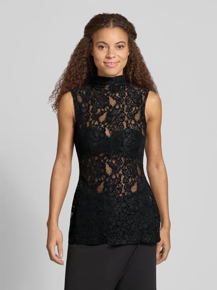 Frauenmodel trägt schwarzes Top aus Spitze mit Stehkragen, Modell 'COCO' von Topshop, Slim Fit, zarte florale Struktur, Ganzkörperansicht von vorne. Rückenlänge bei Größe S: 74 cm.