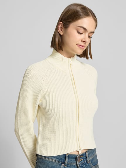 Frauenmodel trägt Slim Fit Jacke aus Baumwoll-Mix Modell 'Dara' von NOISY MAY, cremefarben, Zweiwege-Reißverschluss, Stehkragen, Nahaufnahme Oberkörper.