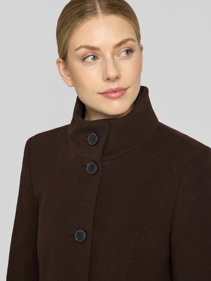 Frauenmodel trägt Regular Fit Mantel aus Woll-Mix mit Kaschmir-Anteil von FUCHS SCHMITT in Dunkelbraun, strukturierte Oberfläche, Nahaufnahme Oberkörper. Taillierte Passform, Stehkragen, Knopfleiste, Eingrifftaschen, glatte Knöpfe, dezente Nähte.