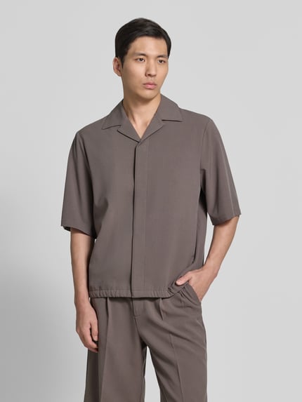 Männermodel trägt Relaxed Fit Hemdjacke mit Reverskragen von Lindbergh in Grau, Material-Mix mit Viskose-Anteil, verdeckte Knopfleiste, Rückenlänge 69 cm, Schulterbreite 48 cm, Ärmellänge 34 cm, Ganzkörperansicht von vorne.