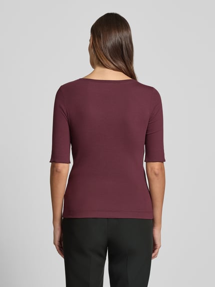 Vrouwenmodel draagt T-shirt met ronde hals en labeldetail van Marc Cain, mix van katoen en elastaan, slim fit, ruglengte maat 36: 55 cm, geheel in bordeaux, gladde textuur, omslag aan de mouwen, rugaanzicht.