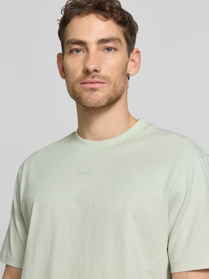 Männermodel trägt Regular Fit T-Shirt aus reiner Baumwolle Modell 'DAPOLINO' von HUGO, Optik: Unifarben, Label-Schriftzug, Nahaufnahme Oberkörper