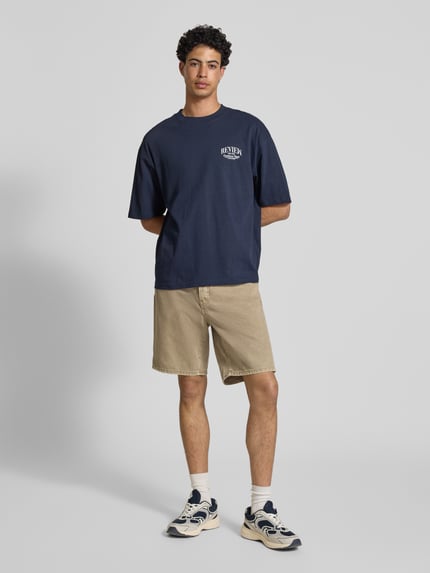 Männermodel trägt Regular Fit Jeansshorts aus reiner Baumwolle Modell 'EDGE' von Only & Sons in Denim-Optik, 5-Pocket-Design, Ganzkörperansicht von vorne.
