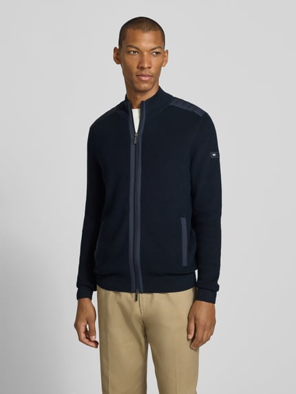 Männermodel trägt Cardigan mit Zweiwege-Reißverschluss von bugatti, Regular Fit, Stehkragen, Eingrifftaschen, Ganzkörperansicht von vorne.