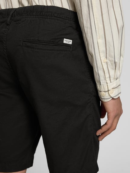 Männermodel trägt zwarte shorts met tunnelkoord, mix van katoen en linnen, regular fit, model 'JAIDEN' van Jack & Jones, detailaufnahme rug.