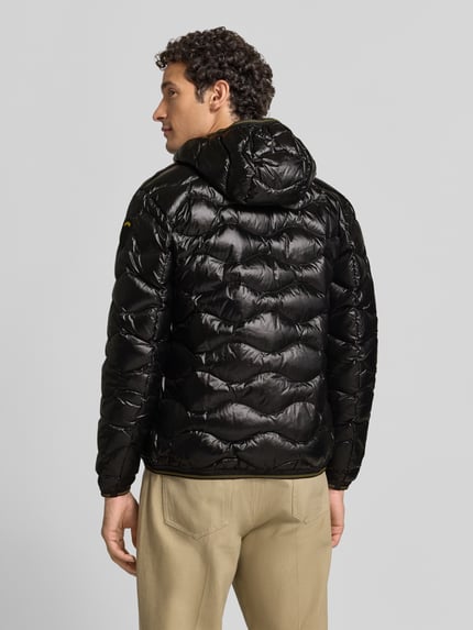 Männermodel trägt schwarze Steppjacke mit Kapuze, Zweiwege-Reißverschluss und Label-Detail, Steppjacke mit Zweiwege-Reißverschluss Modell 'WAVE' von Blauer USA, Rückansicht, Ganzkörperansicht Rückansicht.