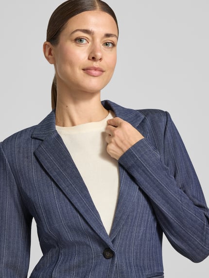Frauenmodel trägt Blazer aus Viskose-Mix mit Reverskragen Modell 'KATE' von ICHI, feine Streifenstruktur, Nahaufnahme Oberkörper. Taillierter Schnitt, Knopfverschluss, Stretch-Anteil, angedeutete Leistentaschen.
