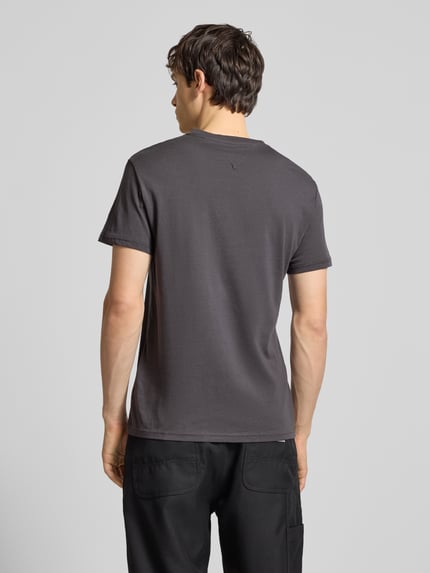 Männermodel trägt Regular Fit T-Shirt aus reiner Baumwolle von Tommy Jeans in Optik: Unifarben, Materialverarbeitung: Jersey, Ganzkörperansicht Rückansicht.