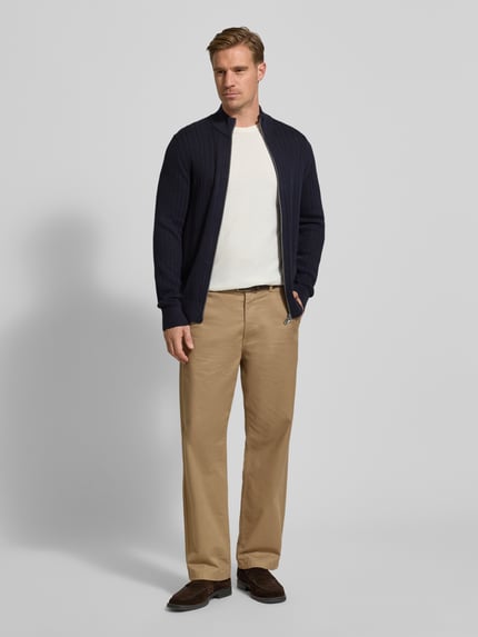 Männermodel trägt Strickjacke mit Reißverschluss von Christian Berg Men aus reiner Baumwolle in Dunkelblau, Ganzkörperansicht von vorne.