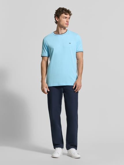 Männermodel trägt T-Shirt mit Kontraststreifen und Rundhalsausschnitt von Christian Berg Men, Baumwoll-Elasthan-Mix, Regular-Fit, hellblau mit dunklen Details, Rückenlänge bei Größe M 71 cm, Ganzkörperansicht von vorne.