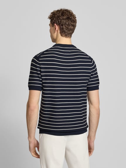 Männermodel trägt Strickshirt mit geripptem Rundhalsausschnitt von MCNEAL, woskowana bawełna, prosty krój, prążkowane wykończenia, długość tyłu 72 cm, długość rękawów 25 cm, widok całej sylwetki z tyłu