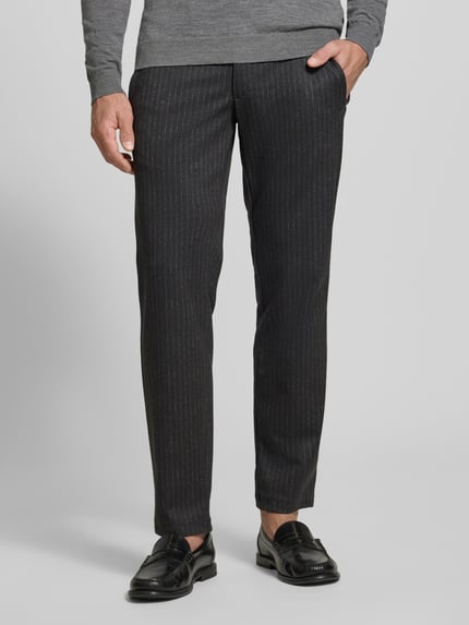 Männermodel trägt eine schwarze Regular Fit Stoffhose mit Viskose-Anteil Modell 'Phil' von Brax, feines Nadelstreifenmuster, Nahaufnahme Unterkörper.