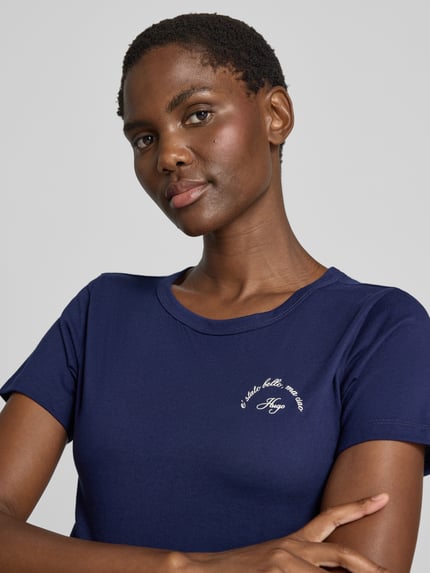 Frauenmodel trägt Regular Fit T-Shirt aus reiner Baumwolle Modell 'DELORIS_5' von HUGO in Dunkelblau, glatte Struktur, Nahaufnahme Oberkörper, Damen T-Shirt von HUGO.