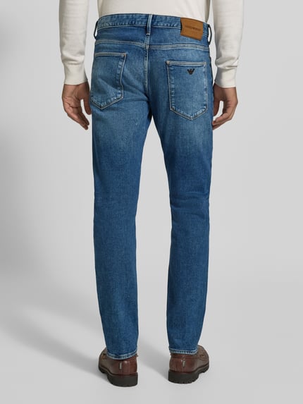 Männermodel trägt Slim Fit Jeans im 5-Pocket-Design von Emporio Armani in Blau, Baumwoll-Mix mit Stretch-Anteil, Ganzkörperansicht Rückansicht.