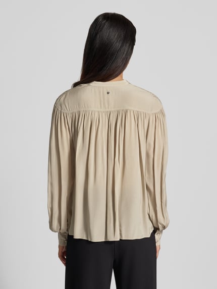 Frauenmodel trägt Regular Fit Langarmbluse aus reiner Viskose Modell 'C_Bethena' von BOSS Orange in Creme mit lockerer Textur, Ganzkörperansicht Rückansicht.