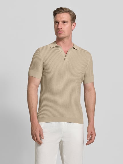 Männermodel trägt Slim Fit Poloshirt aus Viskose-Mix von Antony Morato in Strick-Optik, beige, Polokragen, Kurzärmelig, Ganzkörperansicht von vorne. Rückenlänge bei Größe M: 68 cm, Leinen-Mix.