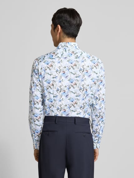 Männermodel trägt Regular Fit Businesshemd aus reiner Baumwolle mit Kentkragen von OLYMP, floraler Allover-Print, Ganzkörperansicht Rückansicht.