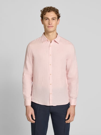 Männermodel trägt Regular Fit Freizeithemd aus reinem Leinen von s.Oliver RED LABEL in Hellrosa, unifarben, mit Kentkragen, Ganzkörperansicht von vorne.