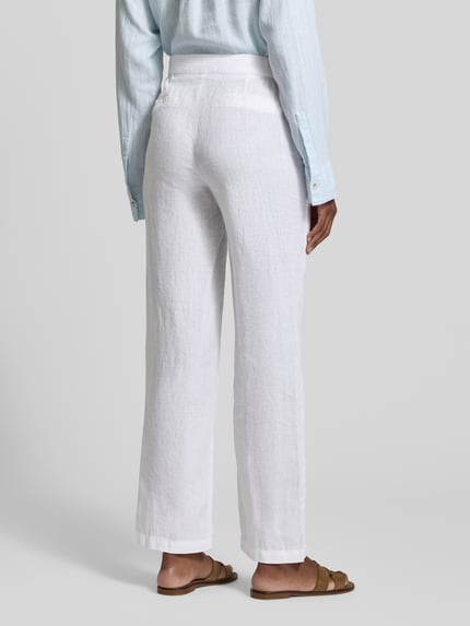 Frauenmodel trägt Straight Fit Leinenhose mit elastischem Bund von Fynch-Hatton in Weiß, Paspeltaschen, reine Leinen, Ganzkörperansicht Rückansicht.