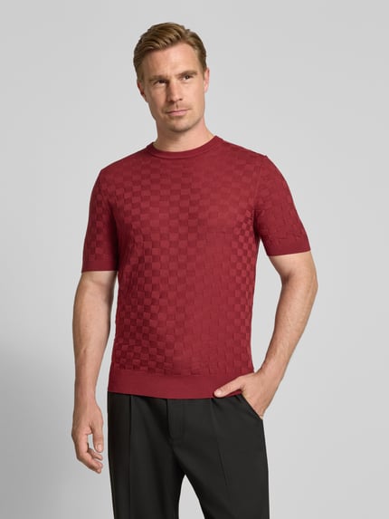 Männermodel trägt Strickshirt mit Struktur-Muster von Antony Morato in Rot, Lyocell-Woll-Mix, Rundhalsausschnitt, Ganzkörperansicht von vorne.