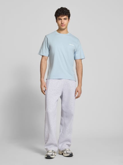 Männermodel trägt Sweatpants mit elastischem Bund und Logo van REVIEW, puur katoen, relaxed fit, logo, binnenbeenlengte maat M 78 cm. Ganzkörperansicht von vorne